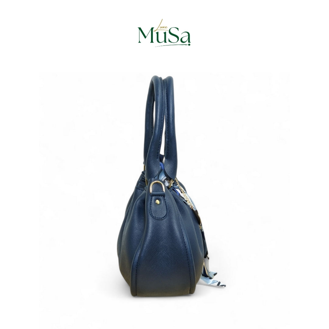Blue handbag with gold accents on a white background, featuring the Musa brand logo.