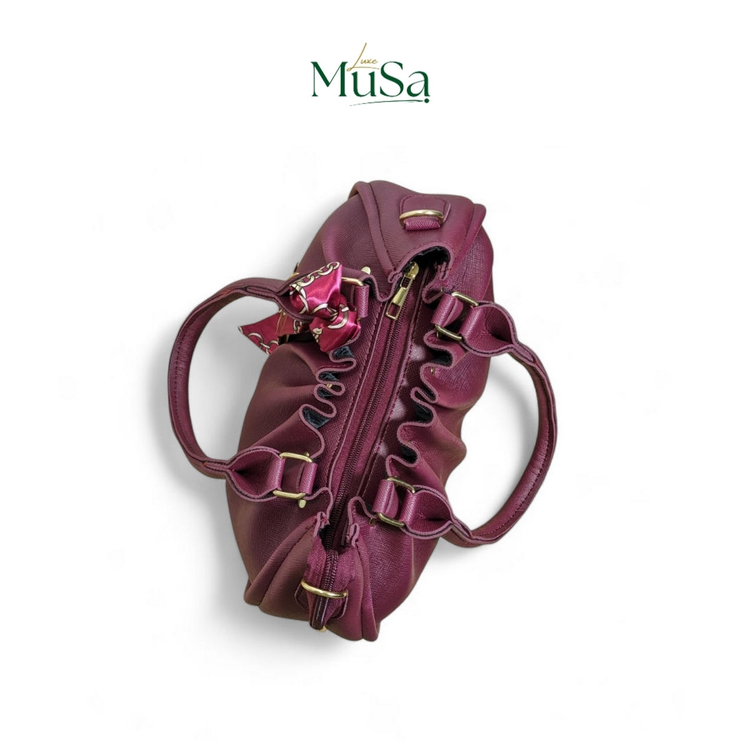 Purple handbag with ruffled details on a white background, featuring the brand 'Luxe MuSa'.